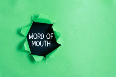 Ağzından çıkanı kulağın duyuyor mu? Yazılmadan iletilen iş fotoğrafı görüntüleme bilgisi. Klasik ahşap bir masanın üzerinde parçalanmış karton..