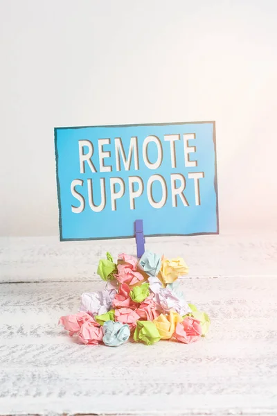 Text sign showing Remote Support. Conceptual photo type of secure service, which permits representatives to help Reminder pile colored crumpled paper clothespin reminder white wooden space.