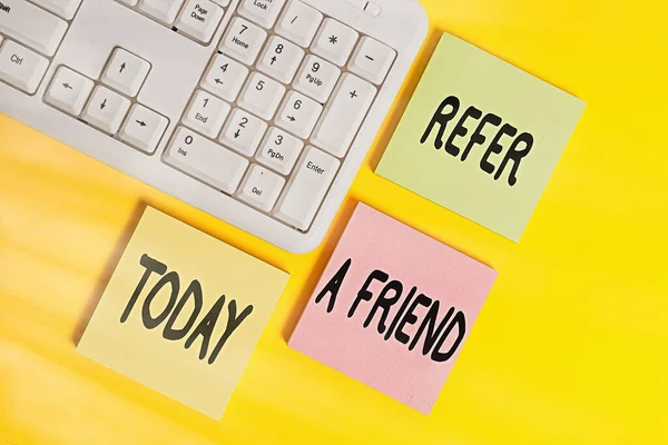 Handwriting text Refer A Friend. Concept meaning direct someone to another or send him something like a gift Colored empty papers with copy space on the yellow background table with pc keyboard. — Stock Photo, Image