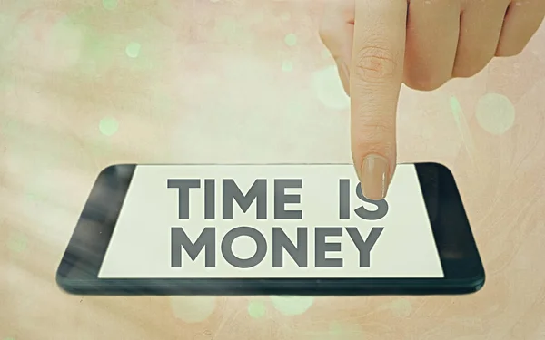 Signo de texto que muestra que el tiempo es dinero. Foto conceptual para hacer las cosas lo más rápido posible y no perder el tiempo Gadgets modernos con pantalla blanca bajo fondo bokeh colorido . —  Fotos de Stock
