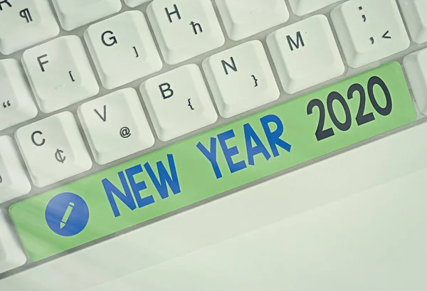 Word writing text New Year 2020. Business concept for Greeting Celebrating Holiday Fresh Start Best wishes Different colored keyboard key with accessories arranged on empty copy space.