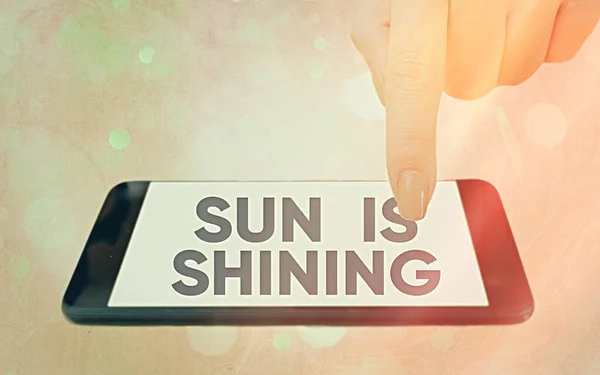 Textovka ukazující Sun Is Shining. Konceptuální foto je něco šíří teplo, štěstí a potěšení Moderní gadgets s bílým displejem obrazovky pod barevné pozadí bokeh. — Stock fotografie