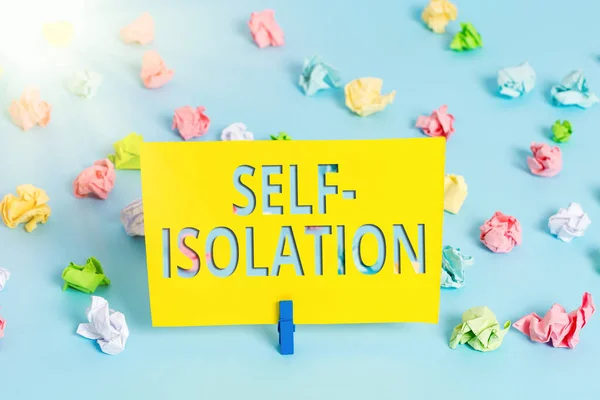 Text sign showing Self Isolation. Conceptual photo promoting infection control by avoiding contact with the public Colored crumpled papers empty reminder blue floor background clothespin.