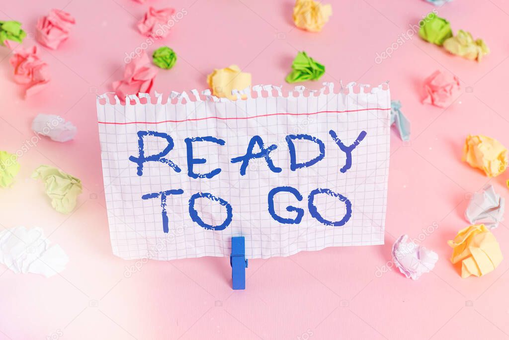 Conceptual hand writing showing Ready To Go. Business photo showcasing prepared and suitable to move or to travel to another place Colored crumpled papers empty reminder pink floor clothespin.
