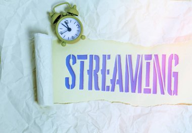 Streaming 'in el yazısı metni. Kavram anlamı süreci, ya da veri akışı ya da veriye erişme durumu Tahta klasik masa arkaplanının üzerine yerleştirilmiş parçalanmış karton parçası.