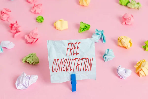 Writing note showing Free Consultation. Business photo showcasing a meeting to discuss something or to get advice for free Colored crumpled papers empty reminder pink floor background clothespin.