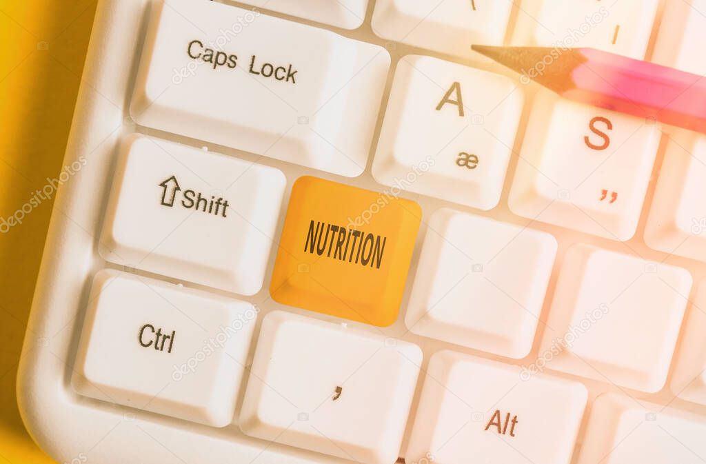 Handwriting text writing Nutrition. Concept meaning act or process of nourishing or being nourished by nutrients Different colored keyboard key with accessories arranged on empty copy space.