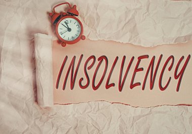 Sözcük yazarlığı, Insolvency. Borçlarını ödeyemeyecek duruma düşmenin iş konsepti tahtadan yapılmış klasik bir masa arkaplanının üzerine yerleştirilmiş parçalanmış karton borçlar..