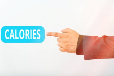Kalorileri gösteren mesaj işareti. Kavramsal fotoğraf. Bir büyük kalori modelinin enerjisine sahip yiyecek miktarı. El işareti ile seyrüsefer ilerlemesini simgeliyor..