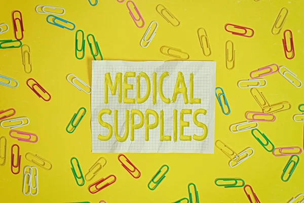 Word writing text Medical Supplies. Business concept for Items necessary for treatment of illness or injury Flat lay above empty paper with copy space and colored paper clips.