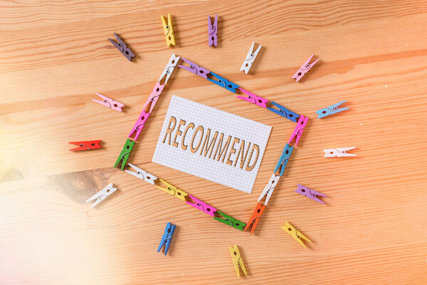 Writing note showing Recommend. Business photo showcasing present as worthy of acceptance or trial, make acceptable Colored clothespin papers empty reminder wooden floor background office.