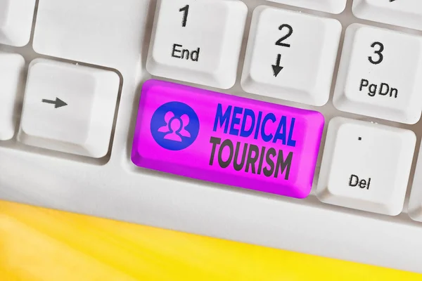 Conceptuele handschrift toont medisch toerisme. Zakelijke foto showcasing reizen naar een ander land op zoek naar medische zorg Gekleurde toetsenbord sleutel met accessoires geregeld op kopieerruimte. — Stockfoto