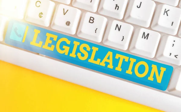 Conceptual hand writing showing Legislation. Business photo text the exercise of the power and function of making rules Colored keyboard key with accessories arranged on empty copy space.