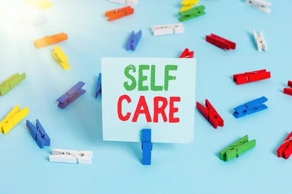 Writing note showing Self Care. Business photo showcasing the practice of taking action to preserve or improve one s is health Colored clothespin papers empty reminder blue floor officepin. — Stock Photo, Image