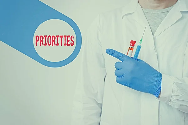 Signo de texto que muestra Prioridades. Foto conceptual hecho o condición de ser considerado o tratado como más importante Mostrando vacío pegatina papel accesorios Smartphone con guantes médicos . — Foto de Stock