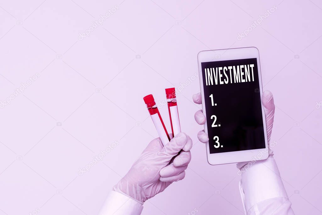 Handwriting text writing Investment. Concept meaning the outlay of money usually for income or profit : capital outlay Extracted blood sample vial with lastest technology ready for examination.