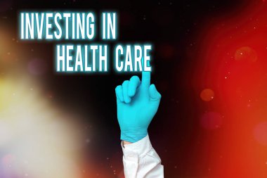 Sözcük yazma metni Yatırım Sağlık Hizmetleri. Tıbbi Eldivenli Boş Kağıt Çıkartma Aksesuarları Gösterme ve Sağlık Bakımı veya Geliştirme üzerine para koyma konsepti.