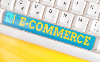 E ticaretini gösteren kavramsal el yazısı. İş fotoğrafı metni, ürün satın almak ve satmak için elektronik iletim aracı kullanır. Boş kopya alanı üzerinde aksesuarlar düzenlenmiş renkli klavye anahtarı.