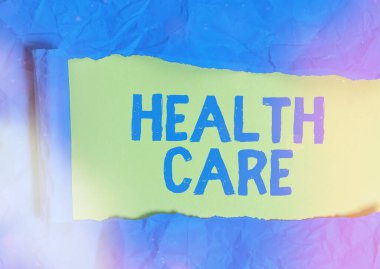 Sağlık Hizmetleri 'nin el yazısı. Konsept, bireylere ya da topluma tıbbi bakım sağlanması anlamına geliyor. Yırtılmış karton, ahşap bir klasik masa arkaplanının üzerine yerleştirilmiş..