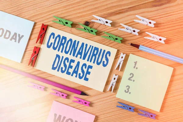 Ordskrivning text Coronavirus sjukdom. Affärsidé för definieras som sjukdom som orsakas av ett nytt virus SARSCoV2 Färgade klädnypor papper tom påminnelse trägolv bakgrundskontor. — Stockfoto