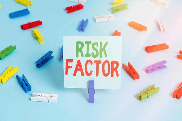 Writing note showing Risk Factor. Business photo showcasing Characteristic that may increase the percentage of acquiring a disease Colored clothespin papers empty reminder blue floor officepin.