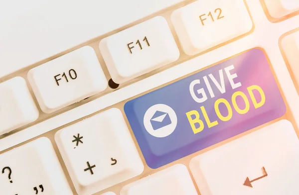 Notiz mit Blutspende. Geschäftsfoto, das eine Person zeigt, die freiwillig Blut abnehmen lässt und für Transfusionen verwendet wird Farbige Tastatur-Taste mit Zubehör auf leerem Kopierraum angeordnet. — Stockfoto