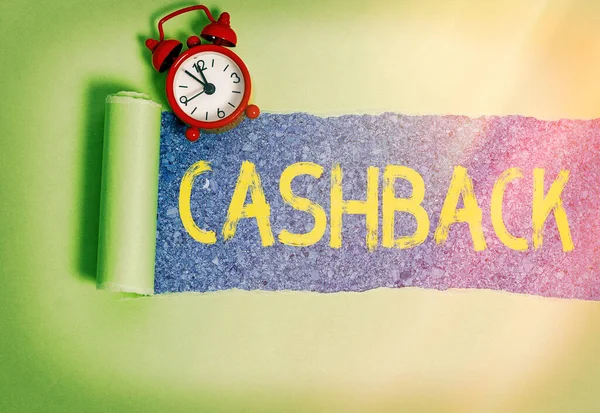 Escritura de texto a mano Cashback. Concepto que significa efectivo real que se puede aplicar a una factura de tarjeta de crédito y recibió cartón desgarrado enrollado colocado sobre un fondo de mesa clásico de madera . — Foto de Stock