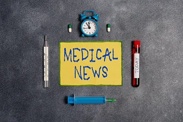 Handwriting text Medical News. Concept meaning report or noteworthy information on a medical breakthrough Extracted blood sample vial with medical accessories ready for examination.