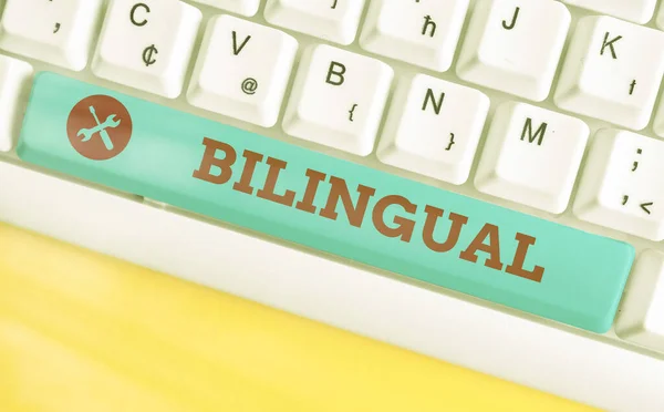 Texto de escritura bilingüe. Concepto que significa usar o poder usar dos idiomas especialmente con igual fluidez Teclado de diferentes colores con accesorios dispuestos en espacio de copia vacío . — Foto de Stock