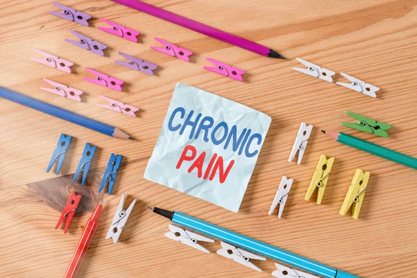 Word writing text Chronic Pain. Business concept for discomfort that persists or progresses over a long period Colored clothespin papers empty reminder wooden floor background office.