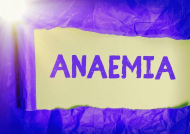 El yazısıyla yazılan anemi. Kavram, kanda hemoglobin eksikliği anlamına gelir. Yırtılmış karton, ahşap bir masa arkaplanının üzerine yerleştirilmiş..