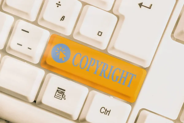 Pisanie tekstu Copyright. Koncepcja biznesowa dotycząca wyłącznego prawa do powielania, publikowania, sprzedaży lub dystrybucji Różnego koloru klawisza klawiatury z akcesoriami umieszczonymi na pustej przestrzeni kopii. — Zdjęcie stockowe