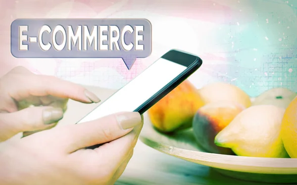 Word writing text E Commerce. Business concept for use electronic transmission medium for buying, selling of product Modern gadgets with white display screen under colorful bokeh background.