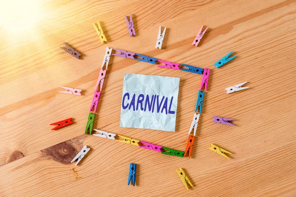 Texto de caligrafia Carnaval. Conceito que significa empresa itinerante oferecendo diversões, exposições, etc. Colorido papéis clothespin vazio lembrete piso de madeira fundo escritório . — Fotografia de Stock