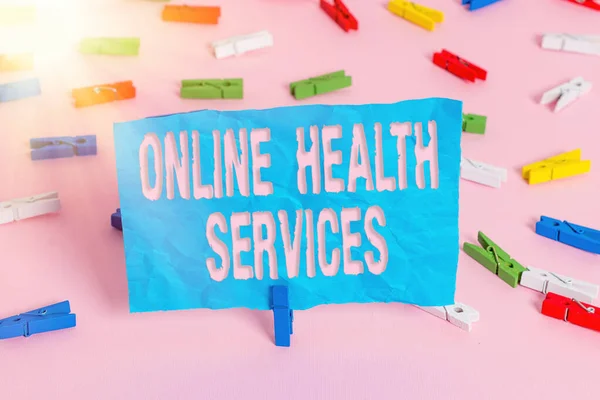 Conceptual hand writing showing Online Health Services. Business photo showcasing healthcare delivered and enhanced through the internet Colored clothespin papers empty reminder pink floor office. — Stock Photo, Image