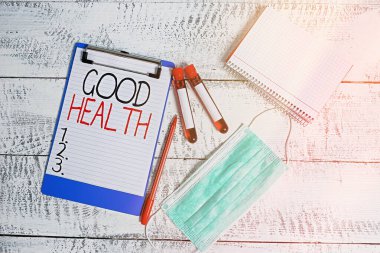 İyi Sağlık 'ı gösteren kavramsal el yazısı. İş fotoğraflarında güçlü ve zihinsel hastalıklardan arınmış olduğu görülüyor. Kan örneği şişesi tıbbi aksesuarlar incelenmeye hazır..