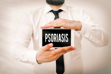 Sedef hastalığını gösteren bir not yazıyorum. Beyaz pullu yamalarla karakterize edilen kronik deri hastalıklarını gösteren bir iş fotoğrafı. Siyah ekran modern akıllı telefon modeli..