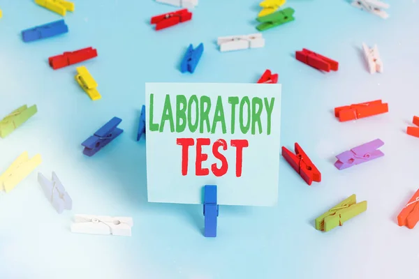 Writing note showing Laboratory Test. Business photo showcasing Determination of a medical diagnosis from the substances tested Colored clothespin papers empty reminder blue floor officepin.