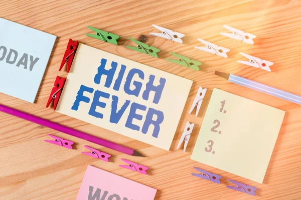 Word writing text High Fever. Business concept for medical condition which the body temperature higher than usual Colored clothespin papers empty reminder wooden floor background office.