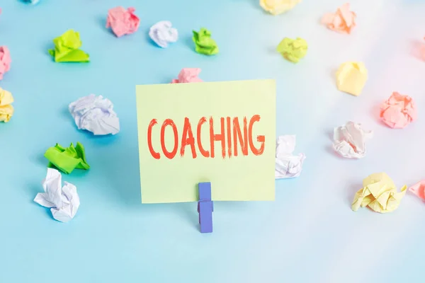 Texto de escritura de palabras Coaching. Concepto de negocio para instruir, dirigir o solicitar como entrenador a los subordinados Papeles arrugados coloreados, recordatorio vacío, pasador de ropa de fondo azul . — Foto de Stock