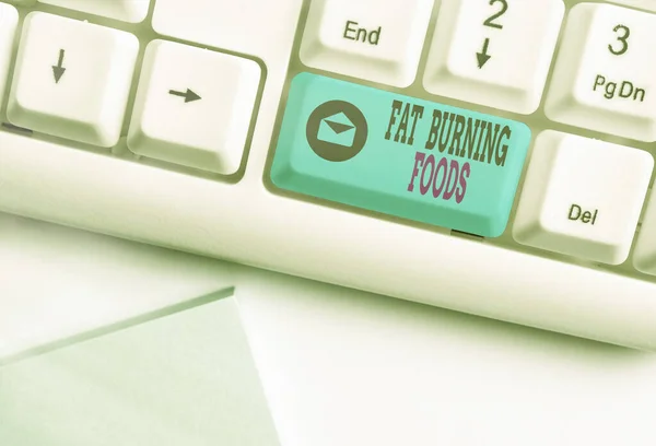 Conceptual hand writing showing Fat Burning Foods. Business photo text produce fat loss by stimulating metabolism to reduce appetite Colored keyboard key with accessories arranged on empty copy space.