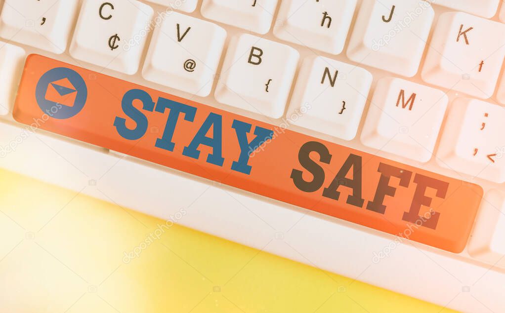 Conceptual hand writing showing Stay Safe. Business photo showcasing secure from threat of danger, harm or place to keep articles Colored keyboard key with accessories arranged on copy space.