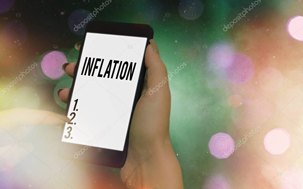 Conceptual hand writing showing Inflation. Business photo showcasing increase in the volume of money relative to available goods Modern gadgets white screen under colorful bokeh background.