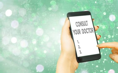 Doktorunuza danıştığınızı gösteren bir mesaj. Kavramsal fotoğraf, renkli bokeh arkaplan altında beyaz ekran ekranı olan tıbbi profesyonel modern aygıtlardan bilgi veya tavsiye isteyin.