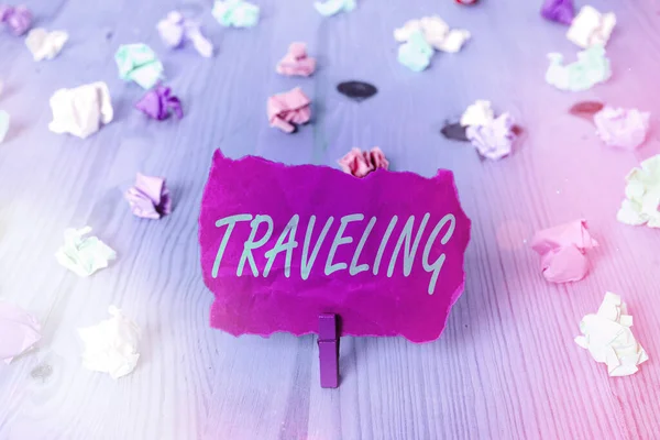 Text sign showing Traveling. Conceptual photo going to different places instead of staying in one place Colored crumpled rectangle shaped reminder paper light blue background. — Stock Photo, Image