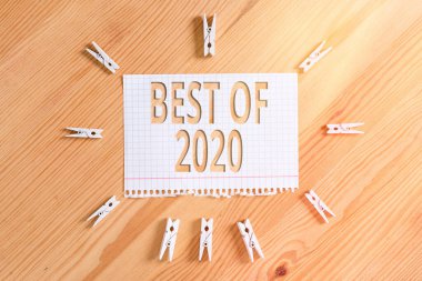 2020 'nin en iyilerini gösteren kavramsal el yazısı. 2020 Renkli, buruşuk kağıtlar ahşap zemin mandalında harika ve muhteşem şeyler ve olaylar gösteren iş fotoğrafı sergilendi..