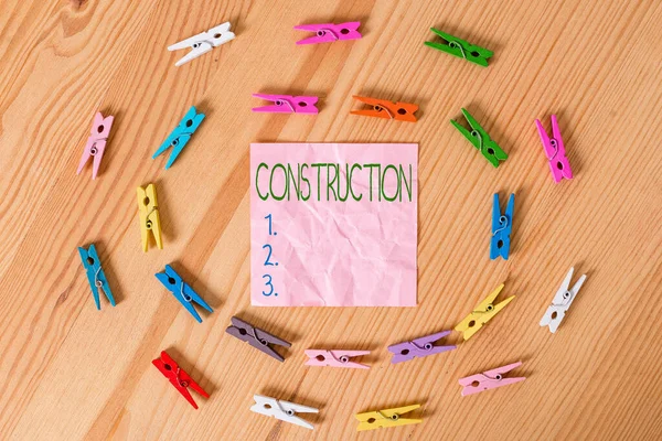 Konceptualne pismo ręczne pokazujące Construction. Biznes zdjęcie układ tekstowy i połączenie słów lub grup słów Kolorowe pogniecione papiery drewniana podłoga tło szpilka. — Zdjęcie stockowe