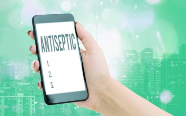 Antiseptiği gösteren bir not yazıyorum. Mikroorganizmayı geciktiren ya da tamamen ortadan kaldıran antimikrobik ajanları gösteren iş fotoğrafı renkli bokeh arka plan altında modern cihazlar beyaz ekran.