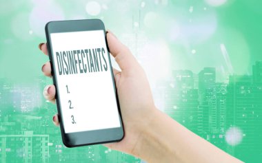 Dezenfektanları gösteren bir not yazıyorum. Zararlı mikroorganizmanın bitkisel formunu yok eden iş fotoğrafı gösterme kimyasalı. Renkli bokeh arka plan altında modern cihazlar..