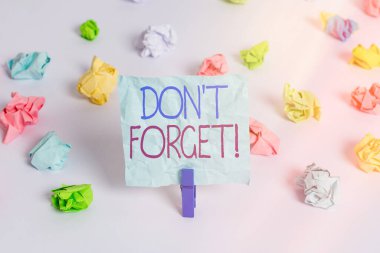 El yazısı metni, unutma. Kavram anlamı birisine önemli bir gerçeği veya detayı hatırlatmak için kullanılır Renkli buruşmuş kağıtlar boş hatırlatıcı beyaz zemin çamaşır mandalı.